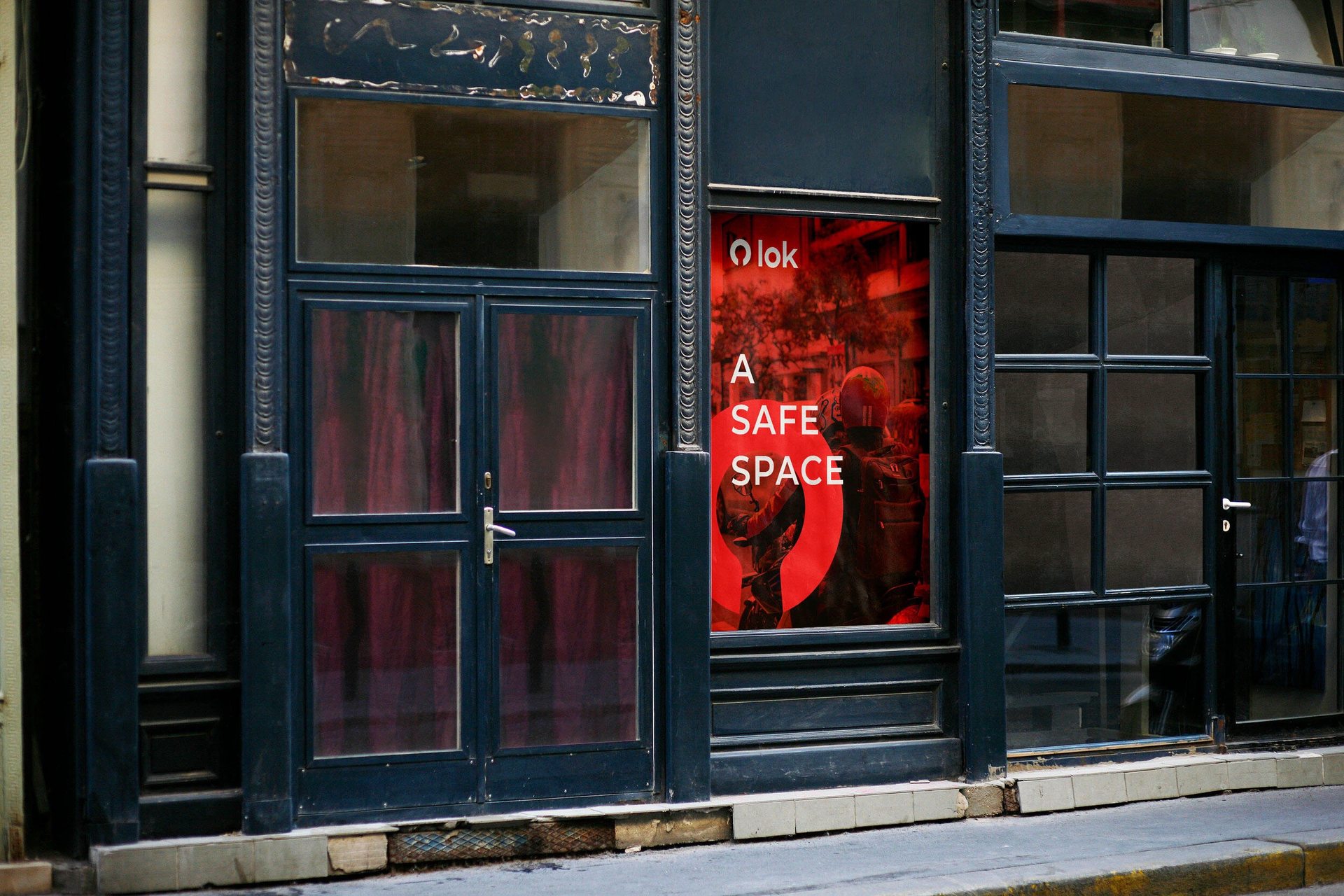 LOK A Safe Space poster in a storefront window