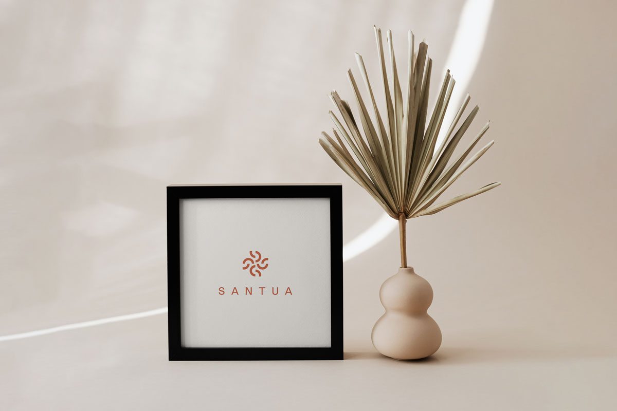 Framed Santua print beside a dried palm frond